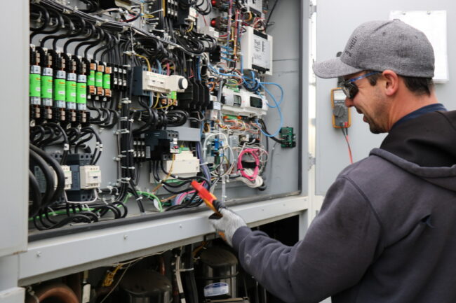 photo of worker in front of electrical panel
